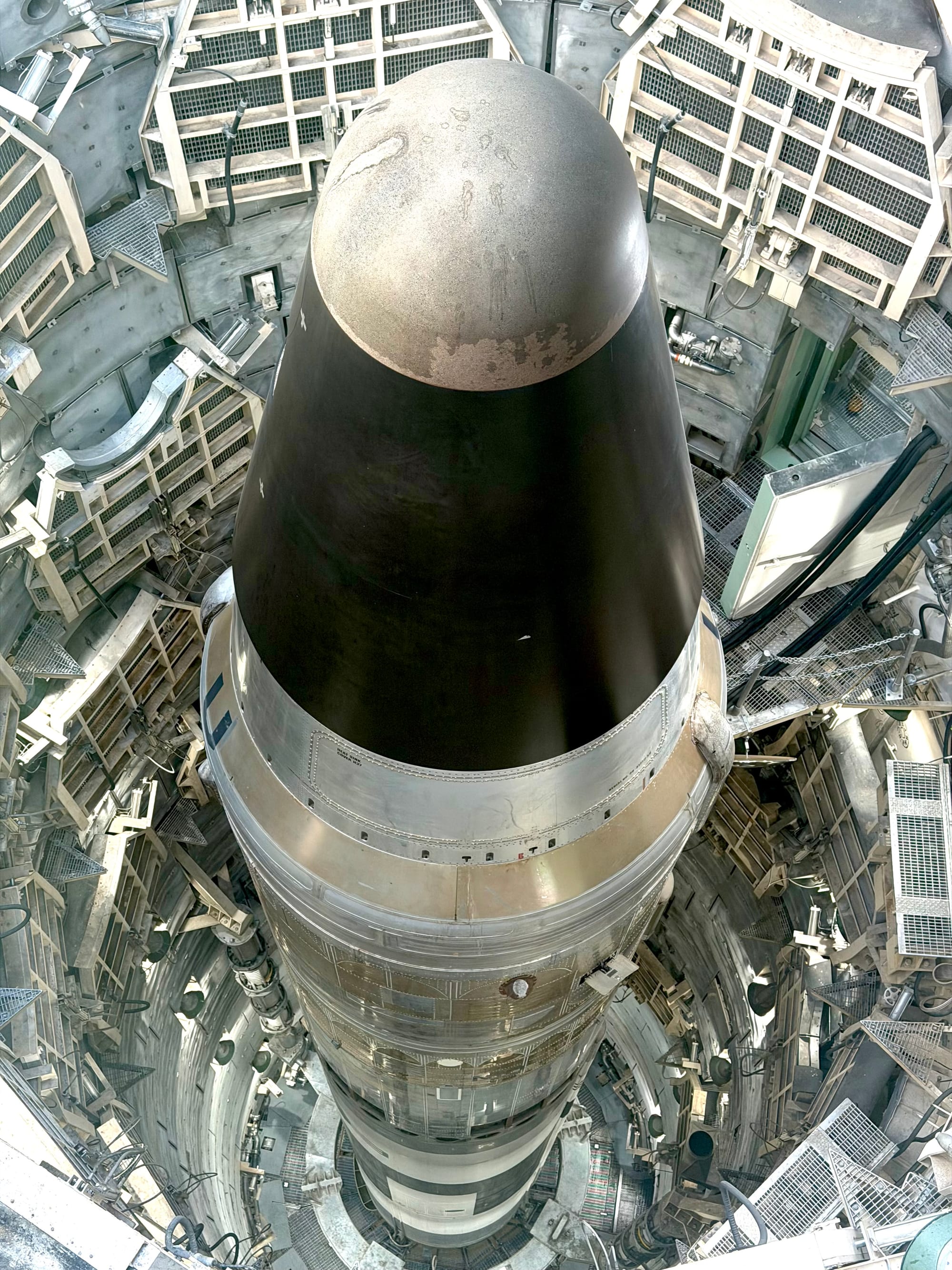 A image looking down into a Titan II Missile silo, with the rocket rising up the entire image.